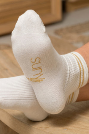 Chaussettes Ginette en coton bio écru, hauteur 10,5 cm, avec deux bandes dorées pailletées et broderie Suny sous le pied