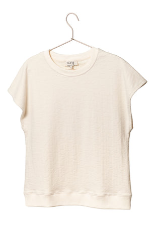 Sweat Gigi en éponge bouclette écru, coupe large et moderne, manches courtes tombantes, porté avec un jean