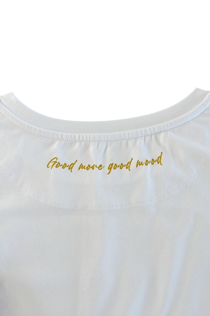 Inscription dorée dans le dos ‘Good move, good mood’ sur tee-shirt de yoga blanc