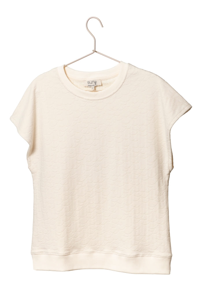 Sweat Gigi en éponge bouclette écru, coupe large et moderne, manches courtes tombantes, porté avec un jean